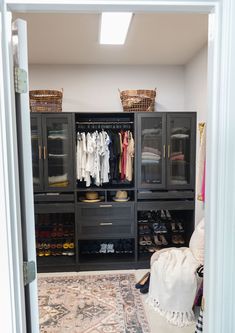 a walk in closet with lots of clothes and shoes on the shelves next to it