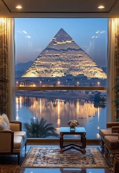 a living room filled with furniture and a view of the egyptian pyramid in the distance