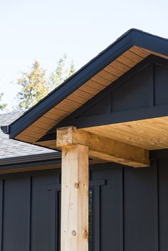 a black house with a wooden roof