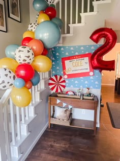 some balloons are hanging from the banisters in front of a staircase with a number 2 sign on it