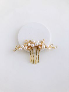 "Our stunning pearl hair comb, a luxurious accessory that will instantly elevate your hairdo and add a touch of elegance to any special occasion. Each pearl has been carefully selected for its lustrous shine, while the delicate zirconia cubes delicately sparkle in the light, creating a truly mesmerizing effect that will turn heads wherever you go. The secure and sturdy design ensures that the comb stays securely in place, allowing you to dance the night away without worry. Make a statement on yo Pearl Hairpiece Wedding, Wedding Hair Pearl Pins, Pearl Hair Combs Wedding, Pearl Hair Piece, Bride Hair Pins, Gold Hair Piece, Pearl Hair Comb Wedding, Pearl Bridal Comb, Pearl Comb