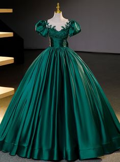 Dazzle the room with elegance in this luxurious emerald Quinceanera gown! Exquisite in its craftsmanship, the dress boasts a fitted bodice adorned with intricate floral appliques that cascade gently over the shoulders, creating an image of garden-esque splendor. The off-the-shoulder sleeves add a touch of classic romance, while the full, flowing skirt, crafted from sumptuous satin, creates a stunning silhouette that's both timeless and regal. Cinched at the waist with a ruched belt detail, this gown accentuates your figure before it balloons into a grandiose, floor-length skirt, ensuring every step you take is a statement of grace. This dress is not only a piece of clothing but a keepsake that embodies the celebration of youth and dreams blossoming into reality.Silhouette:ball gownHemline: Formal Dress Short, Long Tulle Skirt, Green Ball Gown, Occasion Dresses Wedding Guest, Tulle Long Skirt, Satin Ball Gown, A Line Evening Dress, Formal Dresses With Sleeves, Elegant Attire