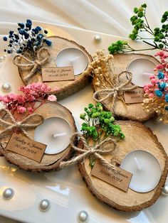 three wooden slices with candles tied to them and some flowers in the middle on a plate