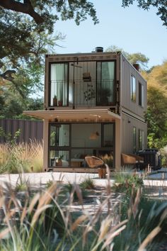 a house made out of shipping containers sitting on top of a lush green field