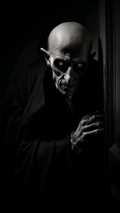 a creepy looking man is peeking out from behind a door with his hands in the dark