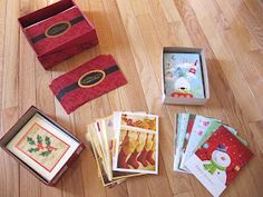 there are many christmas cards in the box on the floor next to it's contents