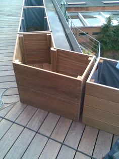 wooden planters are lined up on the roof decking area, which is being used to grow plants