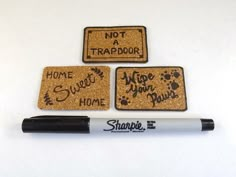 three coasters with words written on them and a marker next to them that says not a trapdoor