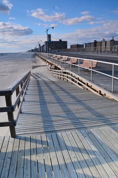 a wooden pier with benches on the beach