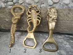 three antique brass door handles on a stone wall