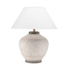 a white lamp sitting on top of a table next to a white light shade over it