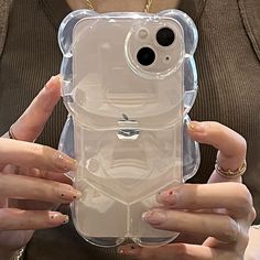 a woman holding an iphone case in her hands with two fingers on the back of it