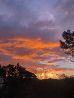 the sun is setting behind some trees