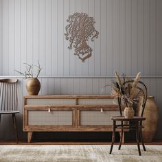 an american flag is hanging on the wall next to two chairs and a vase with flowers