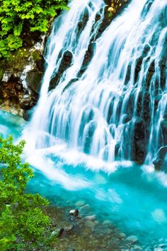 a waterfall with blue water flowing down it's side