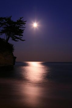 the full moon shines brightly over the ocean