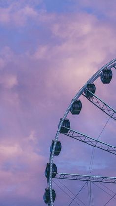 a ferris wheel against a purple sky with clouds