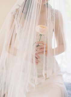 a woman wearing a veil and holding a flower