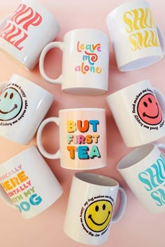 five coffee mugs with different designs on them sitting next to each other in the shape of smiley faces