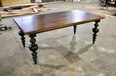 a wooden table sitting on top of a floor next to other woodworking tools and materials