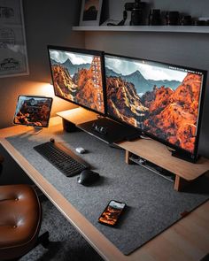 two computer monitors sitting on top of a desk next to a keyboard and monitor screen