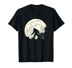 a bigfoot silhouetted against the moon on a black t - shirt with trees