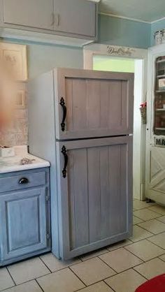 a kitchen with blue cabinets and tile flooring