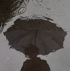 an umbrella is reflected in the water on a rainy day