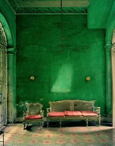 an image of a green room with two couches and a table in the middle