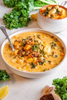 two bowls of soup with broccoli and other vegetables on the table next to it