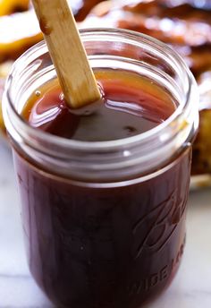 a jar filled with liquid sitting on top of a table next to other food items