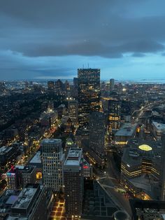 an aerial view of the city at night with lights on and skyscrapers lit up