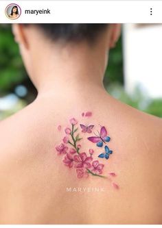 the back of a woman's shoulder with pink flowers and butterflies on her left side