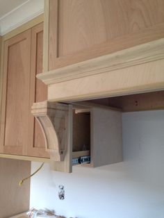 an unfinished kitchen with wooden cabinets and white walls