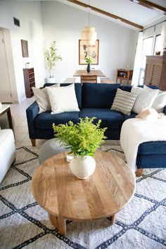 a living room filled with furniture and a wooden table in front of a blue couch