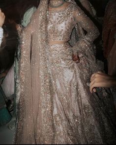 a woman in a silver and gold lehenga