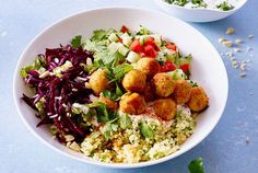 a white bowl filled with salad and meatballs next to another bowl full of vegetables