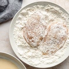 two bowls filled with powdered dough next to each other on a white counter top