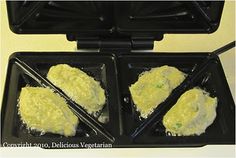 two black trays filled with food on top of a stove