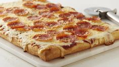 a pepperoni pizza sitting on top of a cutting board