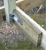 an image of a wooden gate with metal latches on it's side and the bottom part of the fence missing