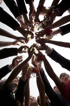 a group of people standing in a circle with their hands on top of each other