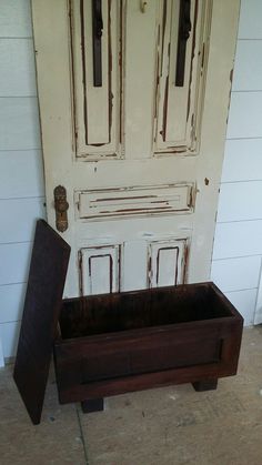 an old wooden box sitting in front of a door