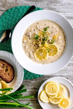 a bowl of soup with lemon slices and bread