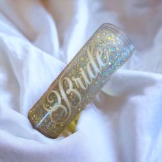 a glittered tumbler with the word bride on it sitting on a white blanket