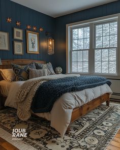 a bedroom with blue walls and white bedding in front of a large window that has framed pictures on the wall