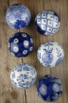 four blue and white vases sitting on top of a wooden table