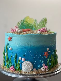 there is a blue cake with sea life on the top and under water plants in the bottom