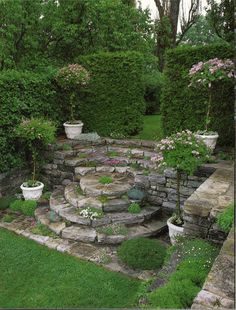 an outdoor garden with stone steps and flowers in the center, surrounded by greenery