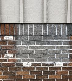 the side of a building with brick and white writing on it that says, don't walk